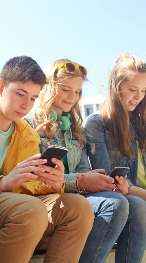 BAMBINI AFFIANCATI CHE GUARDANO IL PROPRIO SMARTPHONE