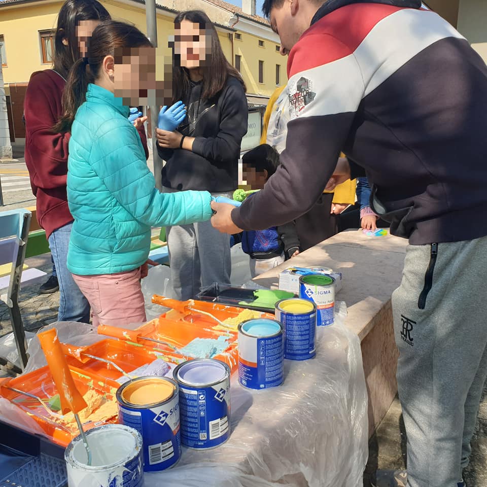 BAMBINI CHE DIPINGONO UNA DELLE PANCHINE PER IL PROGETTO